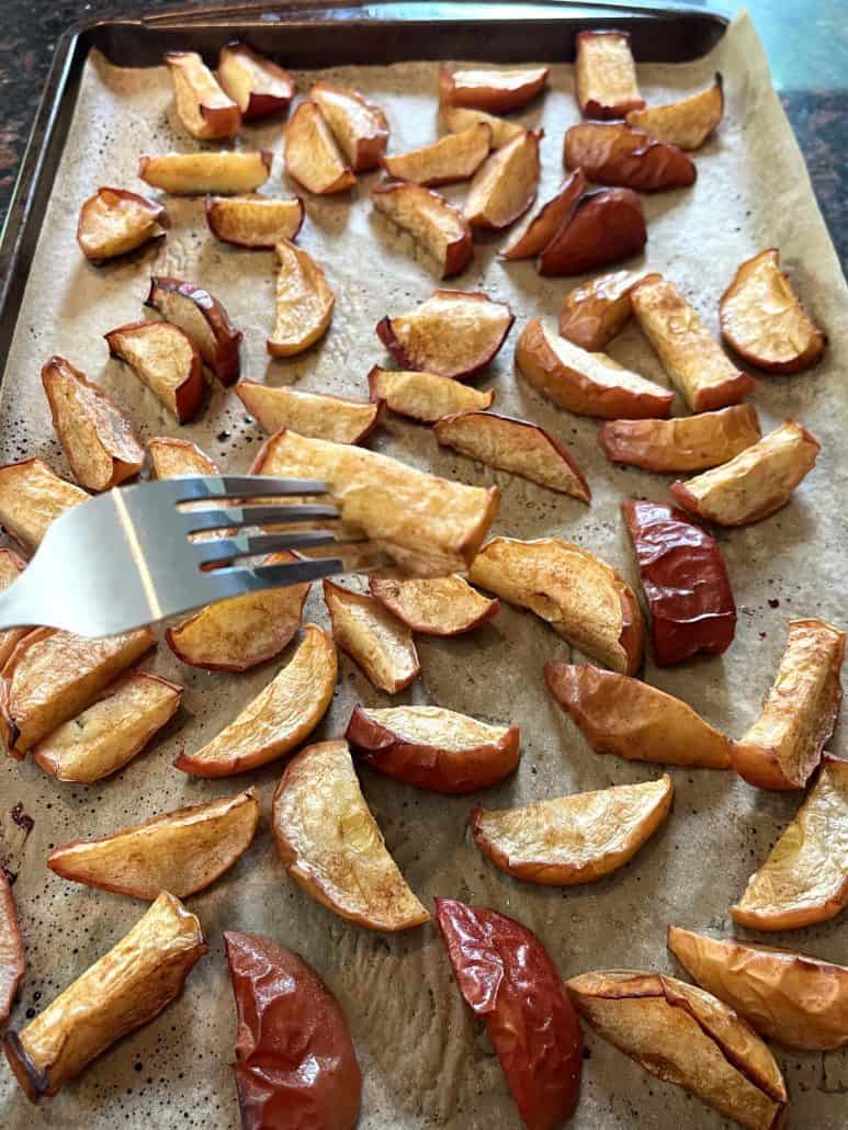 Close-up of roasted apples with a golden, caramelized outside on a plate, showing their soft and juicy inside.