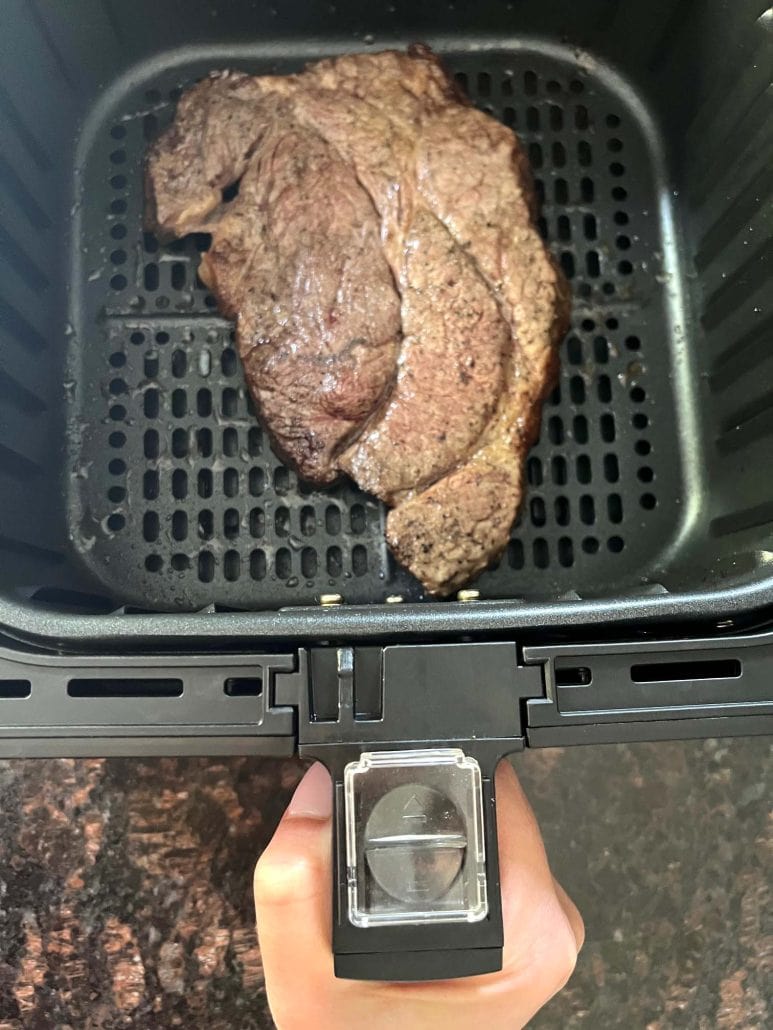 Boneless chuck steak cooked in an air fryer basket, showing a perfectly seared crust.