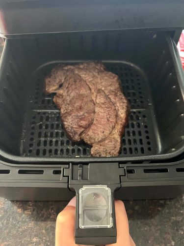 Boneless chuck steak in an air fryer basket, ready to be served after achieving a perfect sear and juicy texture.