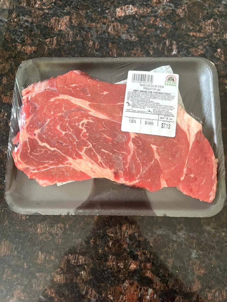 Package of boneless chuck steak on a countertop.