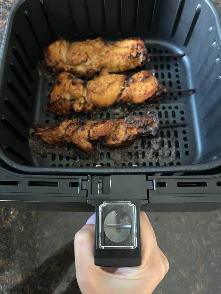 Three air fryer chicken teriyaki skewers in air fryer basket.