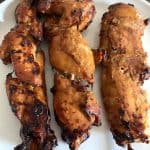 Three pieces of air fryer chicken teriyaki skewers arranged on a white plate.