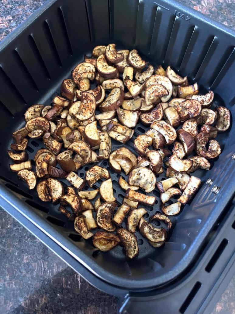 Air fryer basket filled with freshly roasted Chinese eggplant chunks.