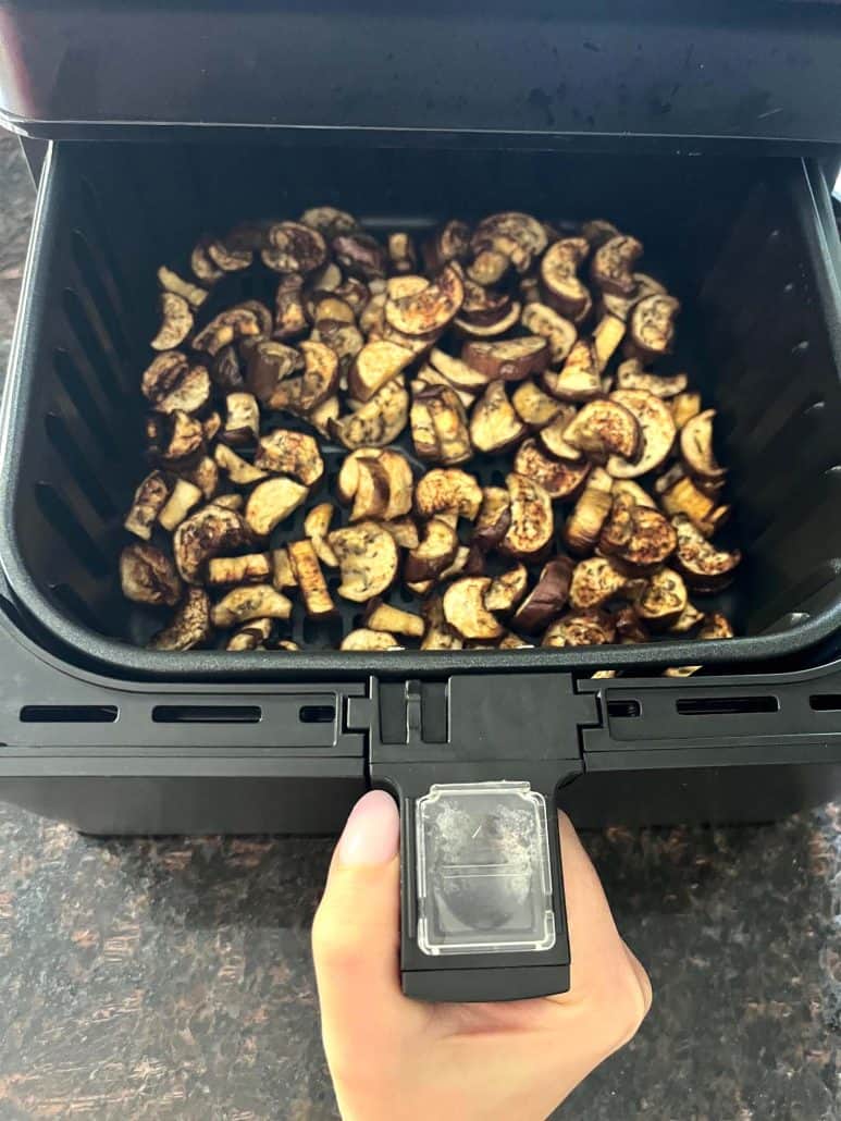 Air fryer basket filled with golden, crispy chunks of Chinese eggplant, freshly cooked and ready to serve as a delicious and healthy side dish.