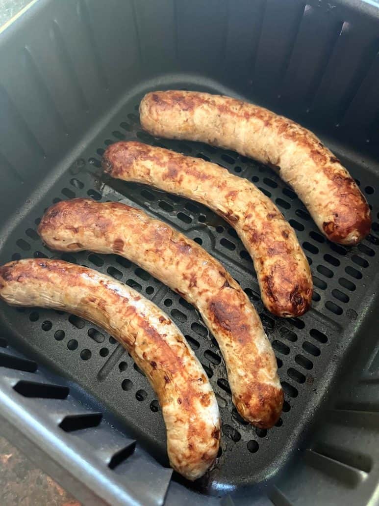 Four roasted Greek sausages in an air fryer.