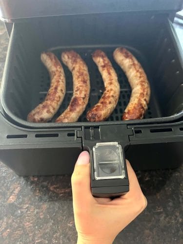 Four pieces of roasted Greek sausage in an air fryer from Melanie at MelanieCooks.com.