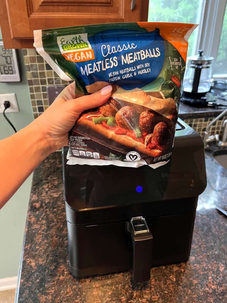 A package of Earth Grown Classic Vegan Meatless Meatballs in front of an air fryer, ready to prepare a quick and easy meal.