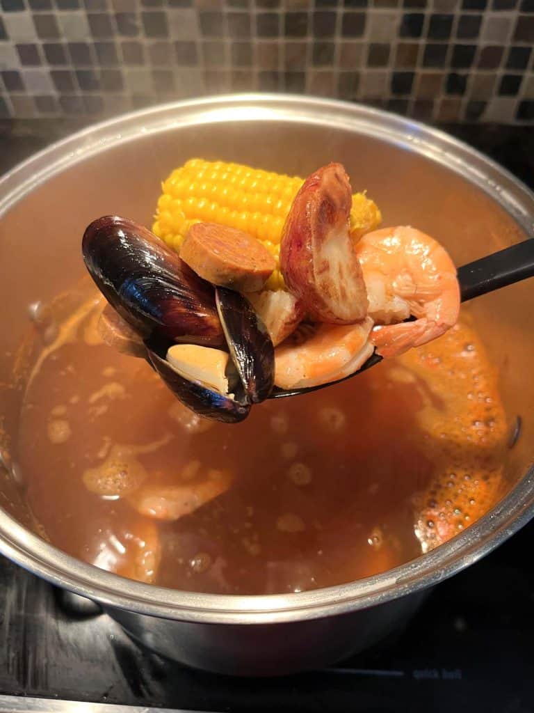 A pot full of boiling Aldi's Frozen Seafood in Cajun-seasoned broth.