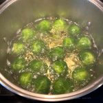 Brussel sprouts boiling in a pot of water, showing the first step in making tender yet crisp boiled Brussels sprouts.