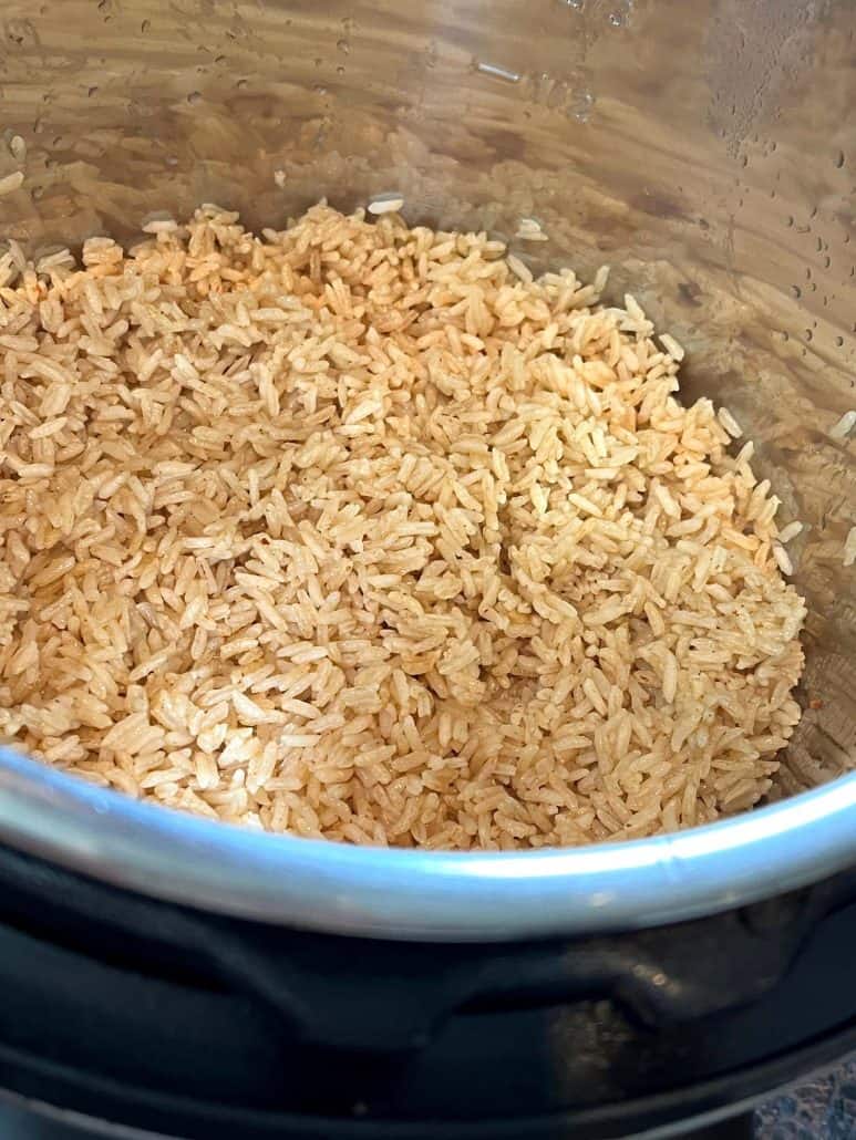 Freshly cooked bone broth rice inside an Instant Pot, with the grains fluffed and perfectly separated.