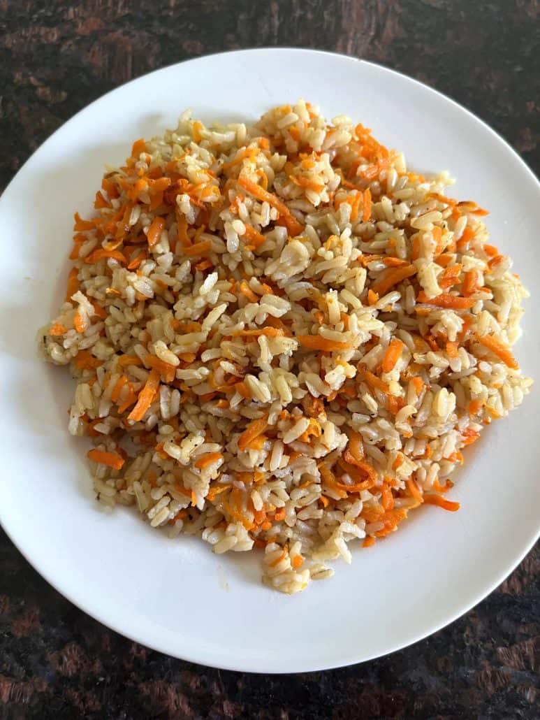 Plate of Carrot Rice, showcasing a simple and nutritious dish made with cooked rice and shredded carrots.