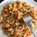 A plate of Carrot Rice with a fork resting on top, ready to be enjoyed as a healthy and flavorful dish.