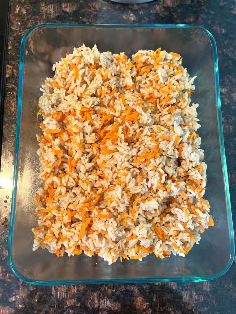 A top view of Carrot Rice in a rectangular glass dish, showcasing the vibrant mix of fluffy rice and shredded carrots, ready to serve.