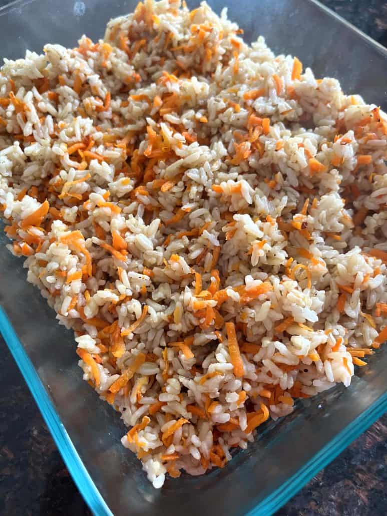 Carrot Rice served in a glass dish, featuring a colorful mix of fluffy rice and shredded carrots, perfect for serving as a side or main dish.