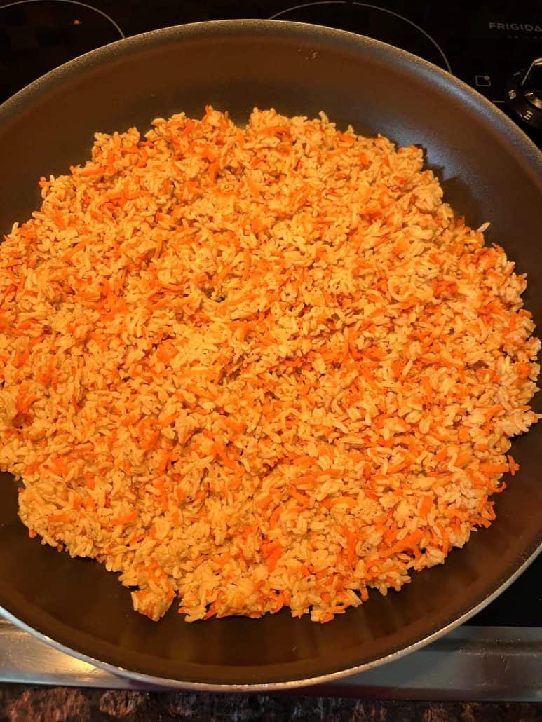 A large pan filled with freshly cooked Carrot Rice, evenly mixed and ready to serve as a flavorful side dish or main course.