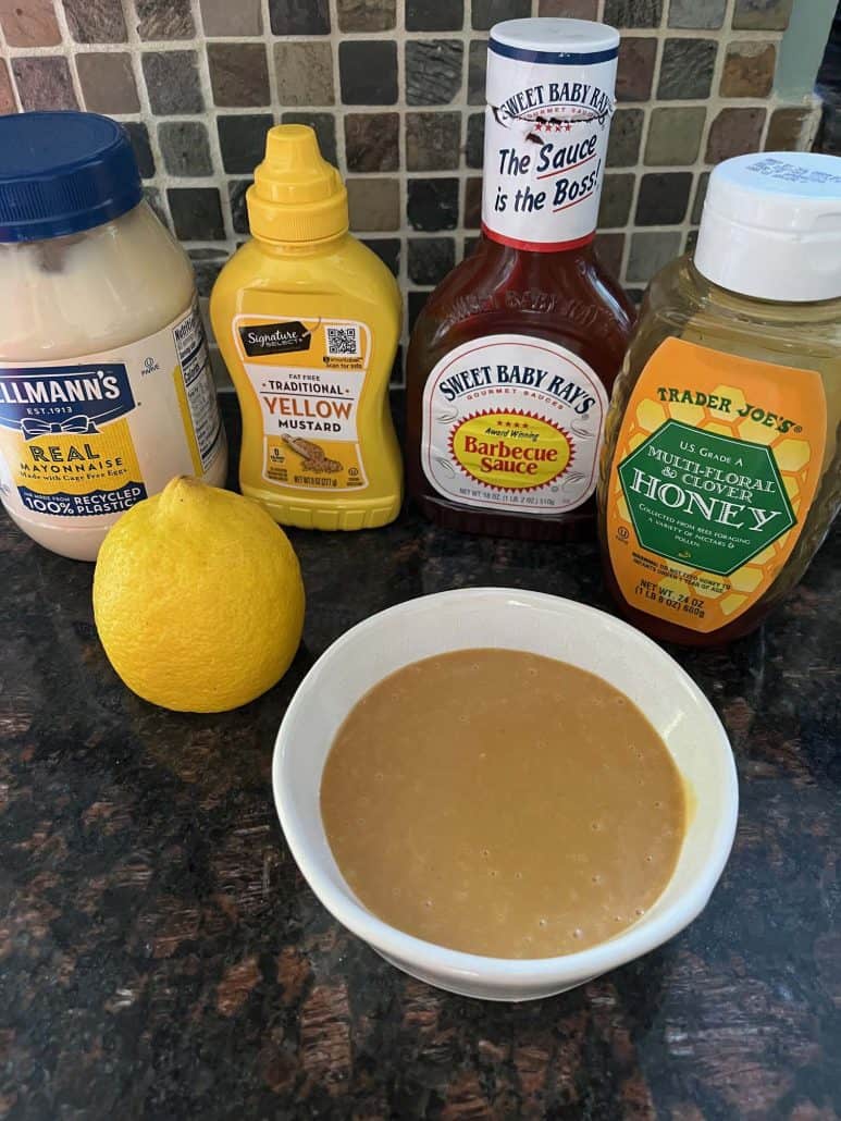 A bowl of homemade Chick-Fil-A sauce with mayonnaise, mustard, barbecue sauce, honey, and a lemon.