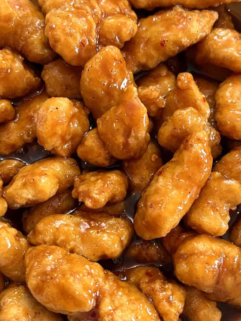  A close-up of air-fried General Tso’s chicken pieces coated in a glossy, flavorful sauce, showing the crispy exterior and rich glaze of the dish.