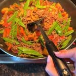 Melanie from melaniecooks.com sautéing mixed vegetables with ground beef.