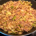 A pan filled with cooked ground turkey and sautéed cabbage, showcasing a healthy and low-carb meal that's easy to prepare.