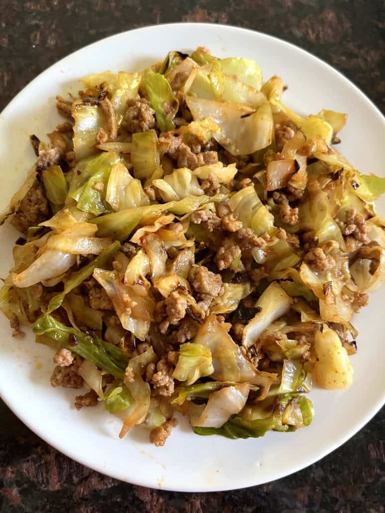 A serving of cooked ground turkey and sautéed cabbage on a white plate.