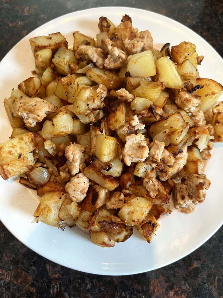 A plate filled with a savory mix of diced golden-brown potatoes and seasoned ground turkey.