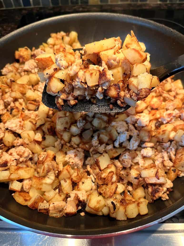 Illustrating the final stages of cooking a hearty skillet meal.