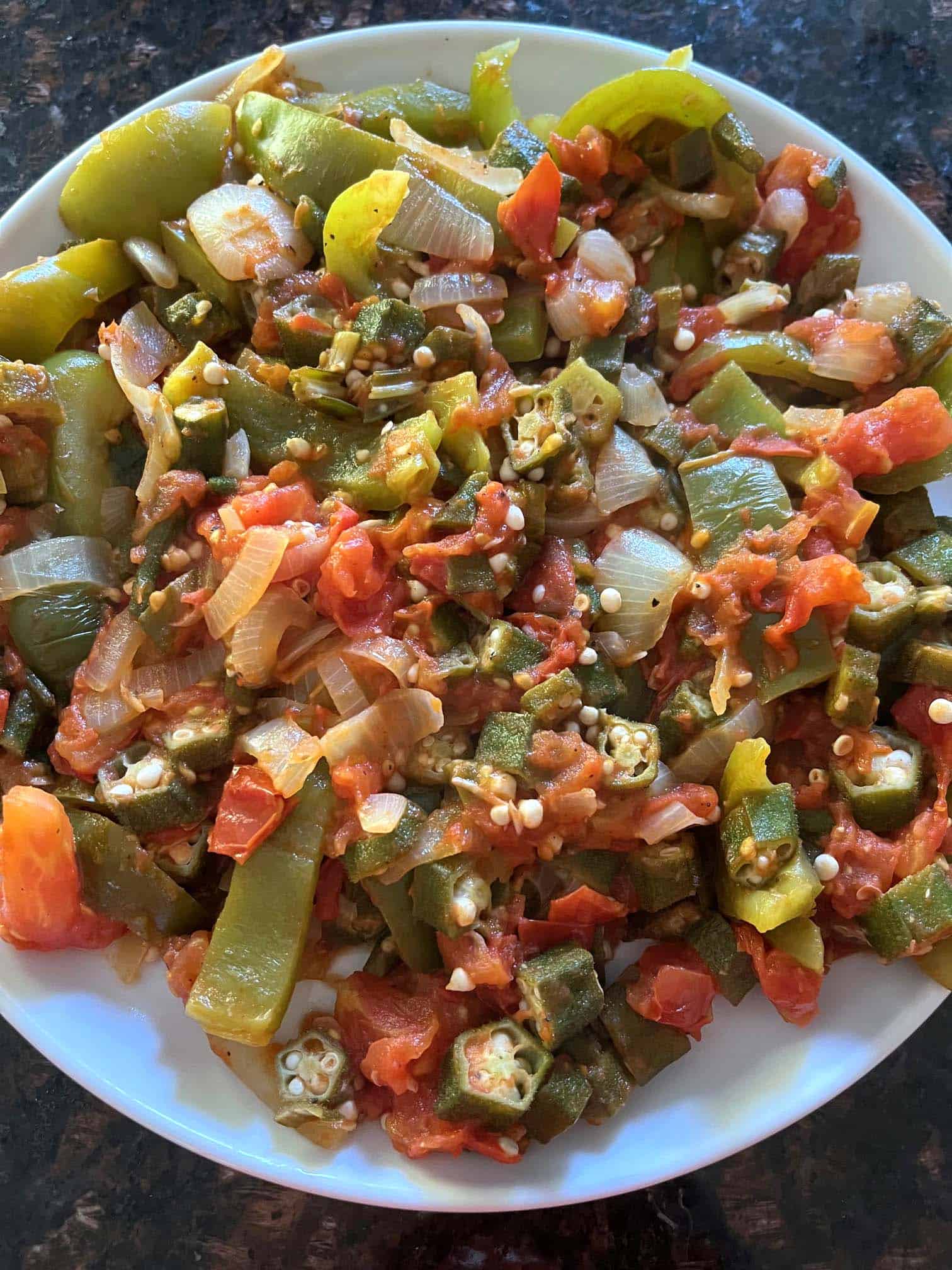 A plate filled with sautéed okra, tomatoes, bell peppers, and onions.