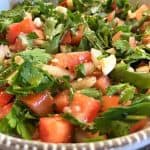 A close-up shot of a parsley salad, highlighting the fresh ingredients and textures.