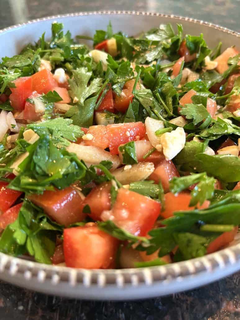 A close-up shot of a parsley salad, highlighting the fresh ingredients and textures.