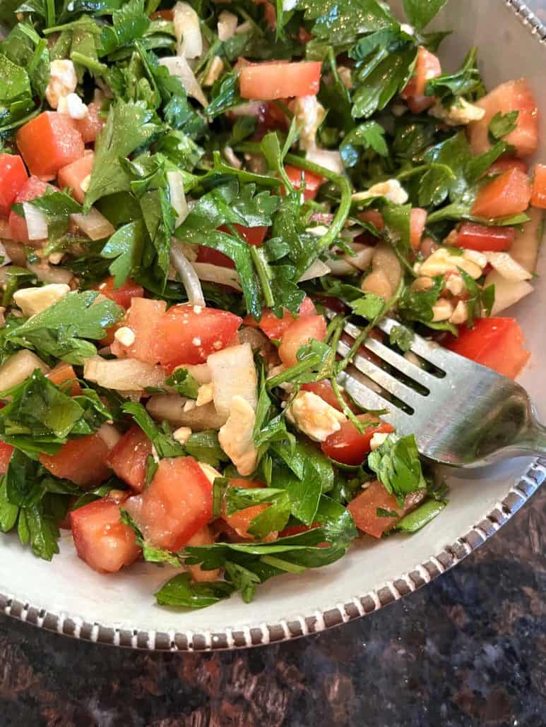 A bowl of salad, showcasing fresh ingredients with balsamic vinegar and olive oil dressing.