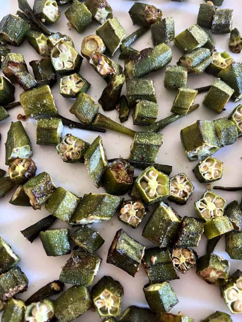 Close-up of roasted okra pieces on a plate, showing their crispy edges and evenly browned texture.