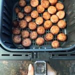 Perfectly browned andouille sausage slices inside an air fryer basket, ready to serve.