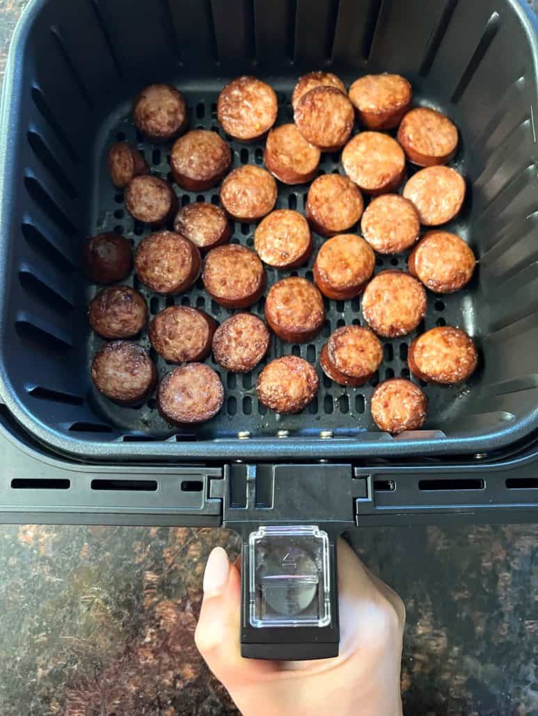 Perfectly browned andouille sausage slices inside an air fryer basket, ready to serve.