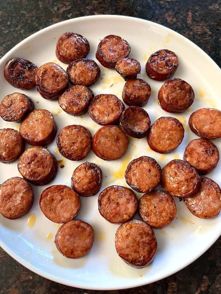 Crispy air-fried andouille sausage slices served on a white plate.