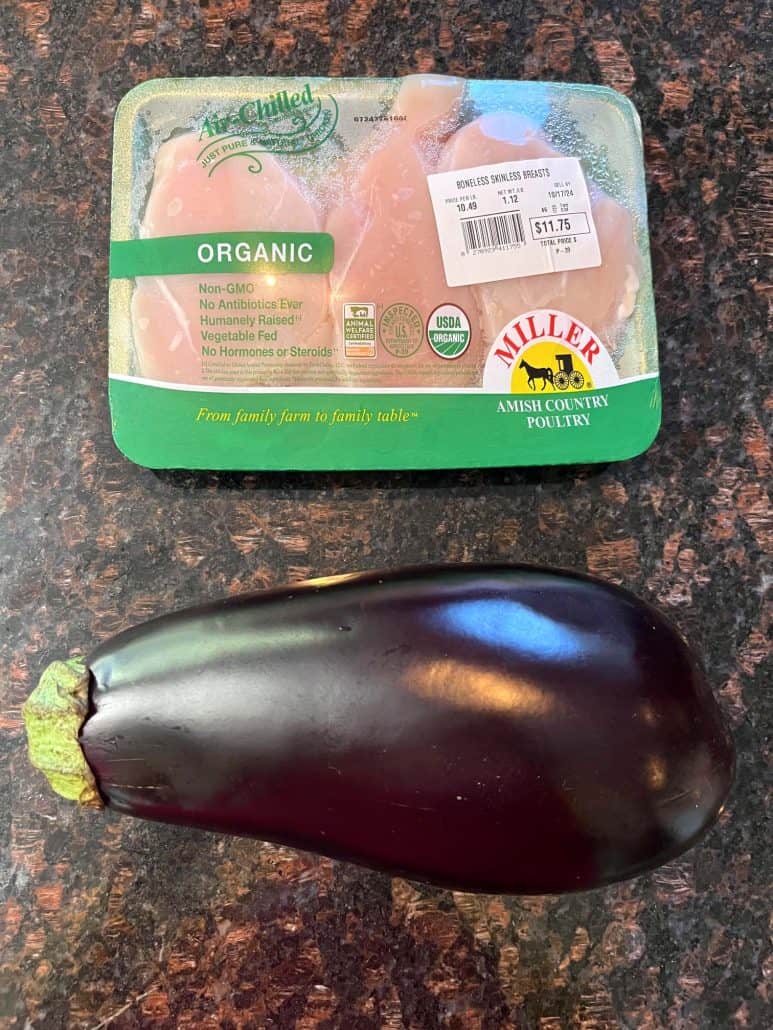 A pack of organic chicken breasts and a whole eggplant on a kitchen countertop, ready to be used for an Air Fryer Chicken and Eggplant recipe