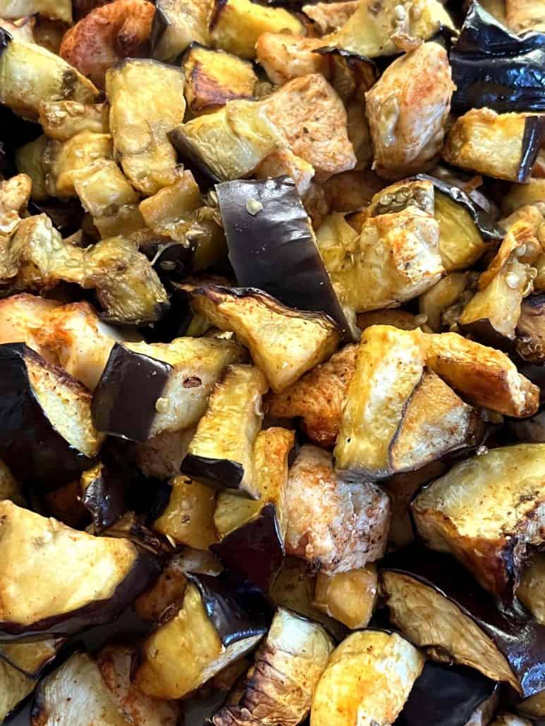 Close-up of golden-brown air-fried chicken pieces and tender eggplant.