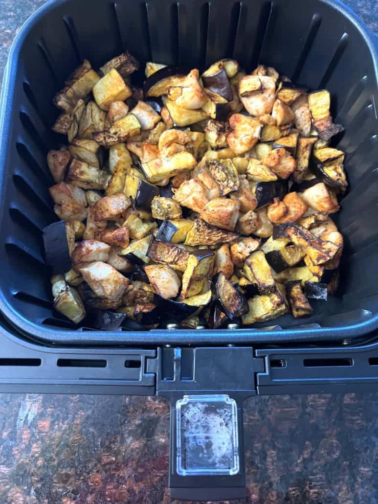 Cooked chicken and eggplant in an air fryer basket, showing the finished result of an easy, low-carb Air Fryer Chicken and Eggplant recipe, with tender chicken and golden brown eggplant pieces.