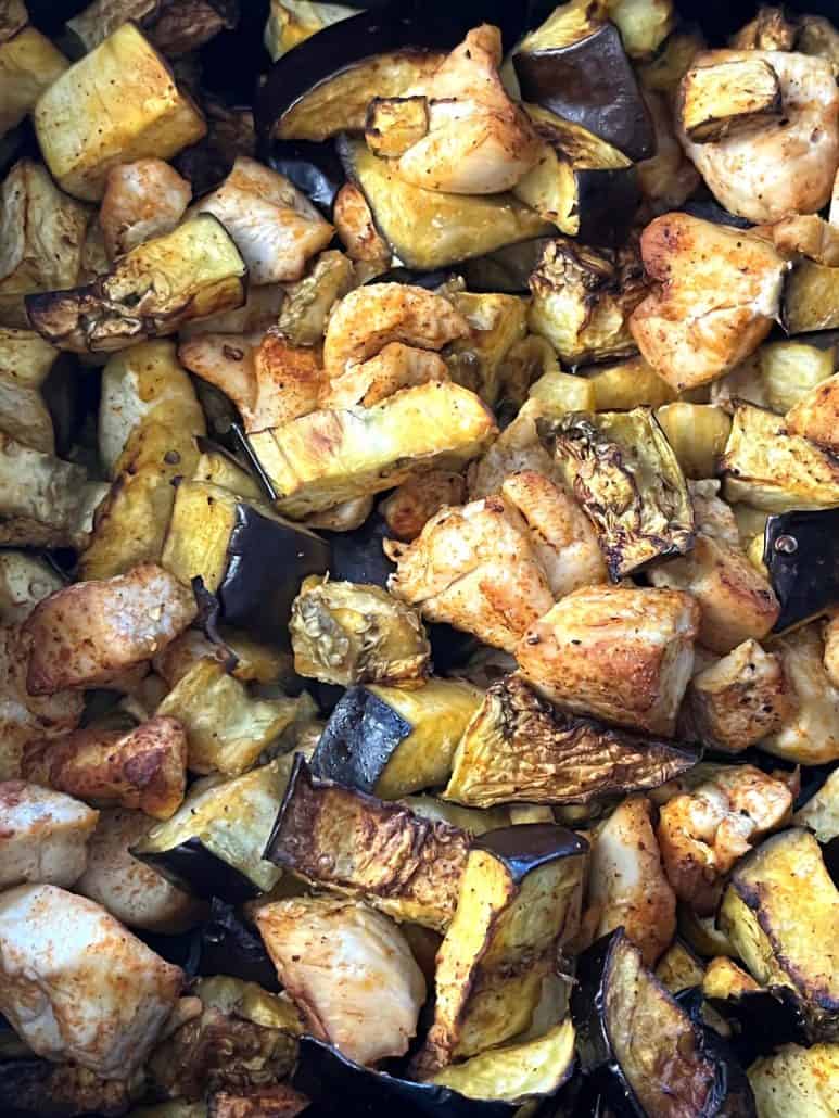 Close-up of air-fried chicken and eggplant pieces.