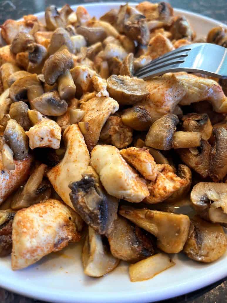 Plate filled with juicy chicken and tender mushrooms.