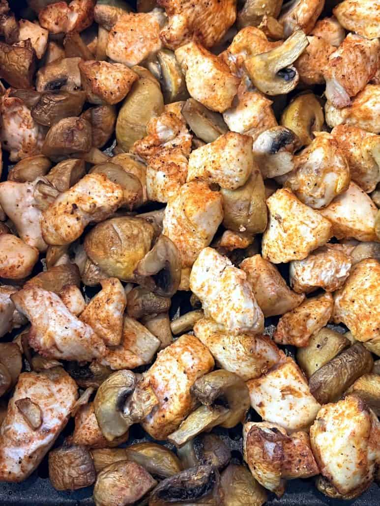 Close-up of golden, seasoned chicken and mushrooms, freshly cook and ready to serve from the Air Fryer Chicken and Mushrooms recipe.