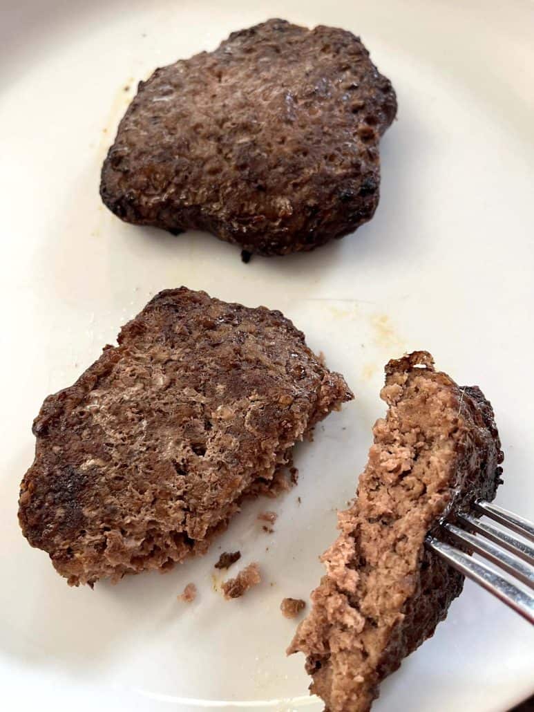 Two air-fried Bubba Burgers on a plate, with one burger cut open to show the juicy, cooked interior.