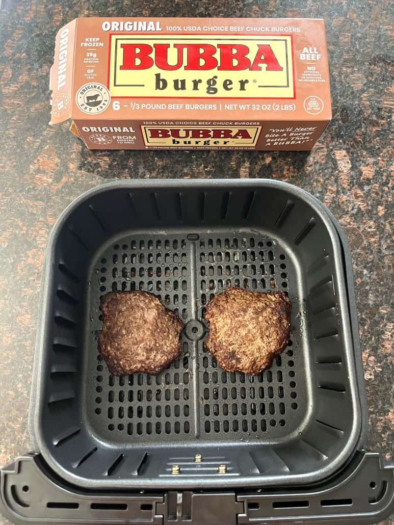 Cooked Bubba Burgers in an air fryer basket with the Bubba Burger box in the background.