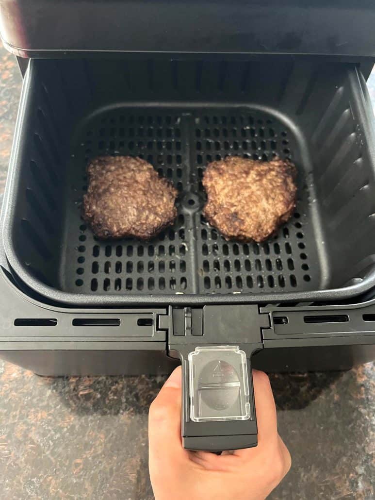 Cooked Bubba Burgers in an air fryer basket, showing the browned, crispy exterior.