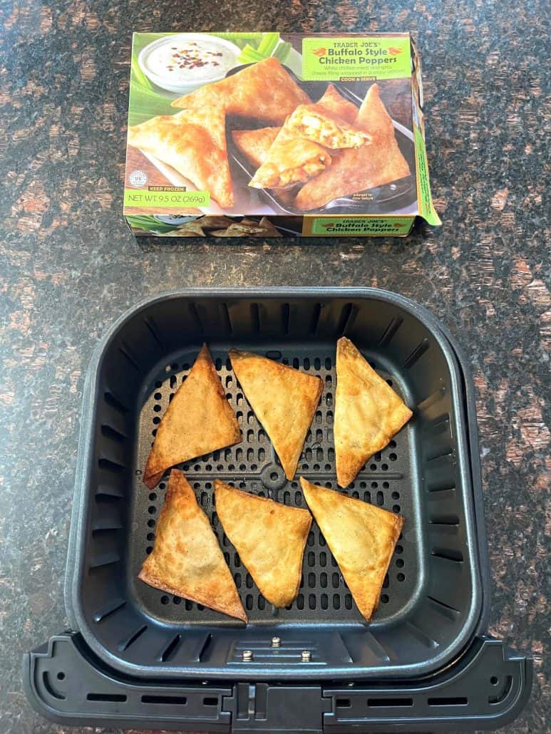 Crispy Buffalo Style Chicken Poppers freshly cooked in an air fryer basket with the packaging box displayed above, showing the finished result.