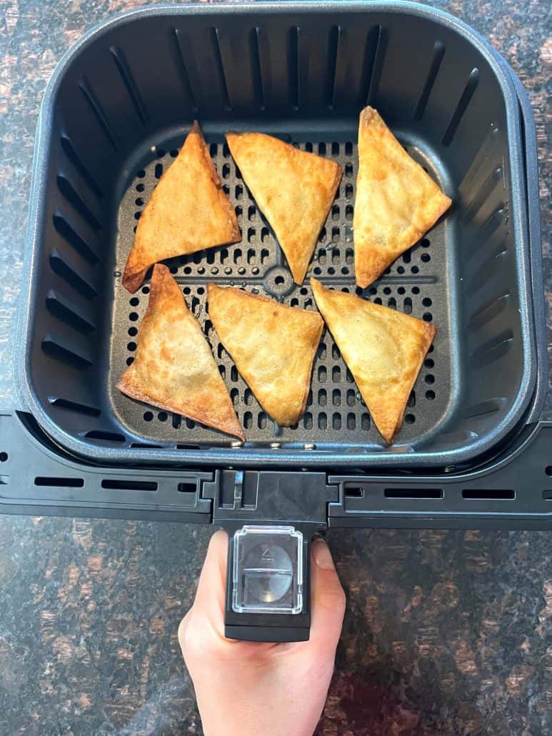 Golden-brown crispy chicken poppers in an air fryer basket, perfectly cooked straight from frozen.