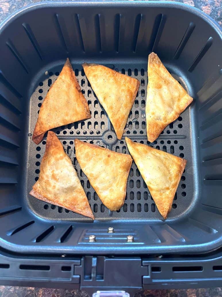 Six golden and crispy Buffalo Style Chicken Poppers cooked in an air fryer basket, ready to serve.