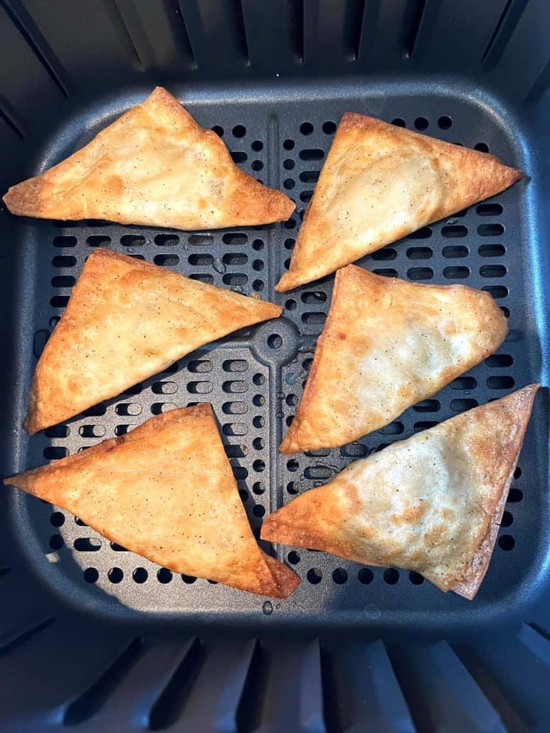 Buffalo Style Chicken Poppers cooked to a golden crisp in an air fryer basket.