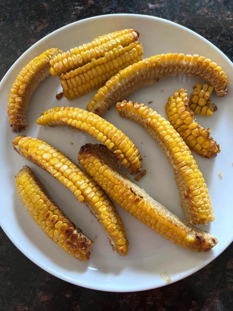 Plate of golden, air-fried seasoned corn ribs, ready to enjoy as a tasty side or snack.