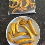 Air-fried Trader Joe's seasoned corn ribs served on a plate next to the original packaging.