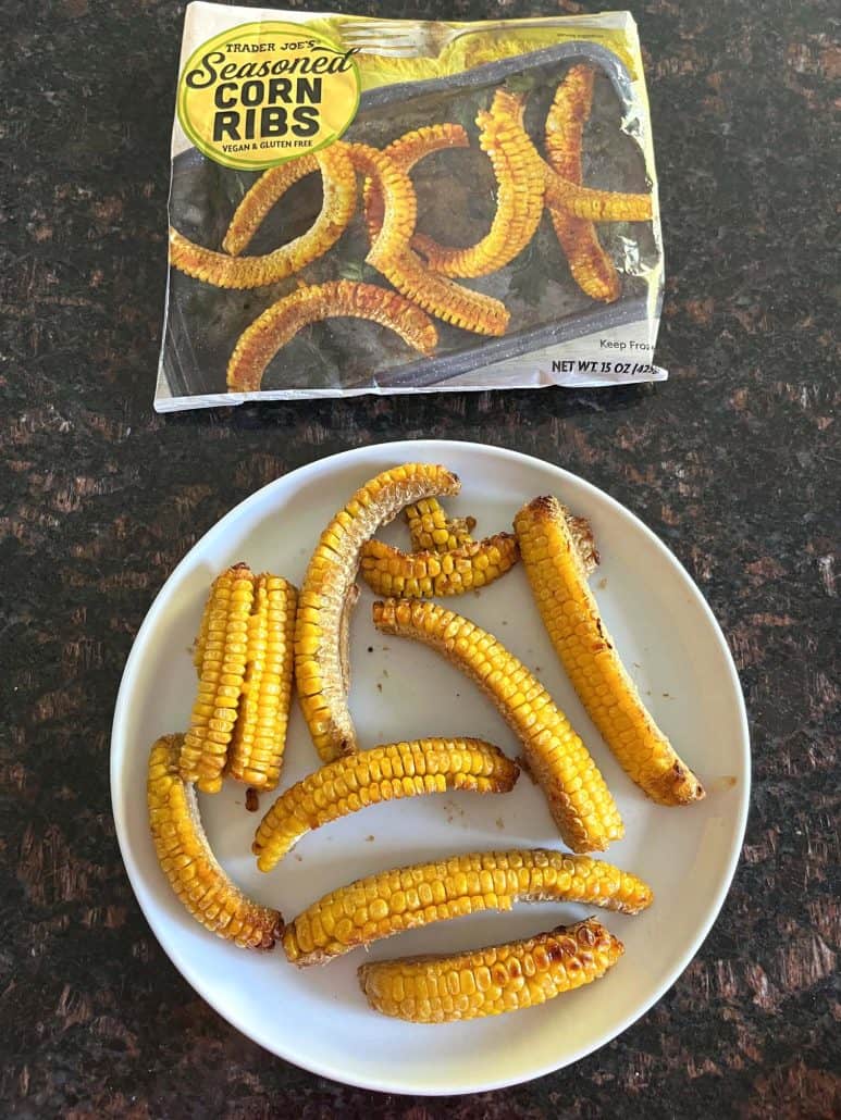 Air-fried Trader Joe's seasoned corn ribs served on a plate next to the original packaging.